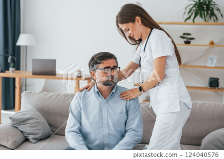 Working with mature man. Professional nurse is in white coat is in the office 124040576