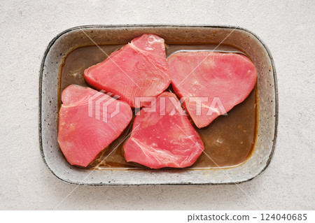 Four pieces of raw tuna marinating in soy sauce and lemon juice in a rectangular dish Four pieces of raw tuna marinating in soy sauce and lemon juice in a rectangular dish 124040685