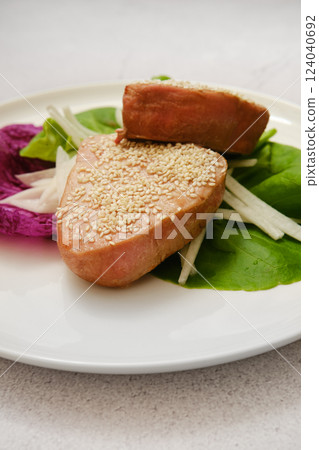 Freshly prepared tuna fillet with sesame seeds and vegetables on a plate 124040692