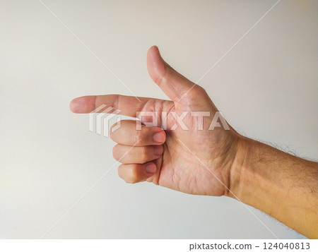Closeup of a male hand gesturing, pointing with index finger.  Clean, simple background ideal for presentations, websites, or instructional materials.  Versatile image for various design projects. 124040813