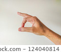 Closeup of a hand gesturing a small size or amount.  Perfect for illustrating concepts of measurement, quantity, or comparison. 124040814