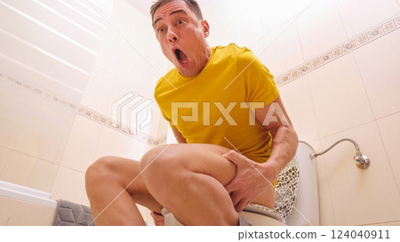 Man exulting while sitting on toilet after achieving goal 124040911