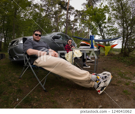 Couple Relaxing at Campsite with Hammock and Car Couple Relaxing at Campsite with Hammock and Car 124041062