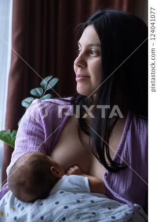 Mother Breastfeeding Baby by Window 124041077