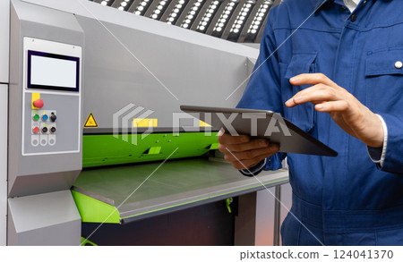 Engineer uses a digital tablet to control CNC in a smart factory. Smart industry 4.0 concept. 124041370