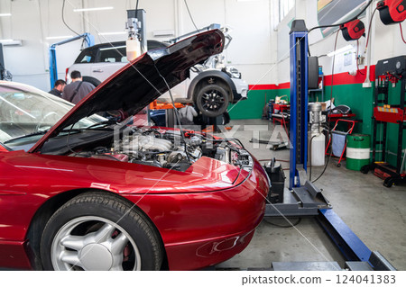 Car service workshop with cars on a column lifts 124041383