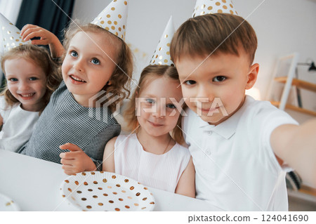 Making selfie. Celebrating brithday. Group of children is together at home at daytime Making selfie. Celebrating brithday. Group of children is together at home at daytime 124041690