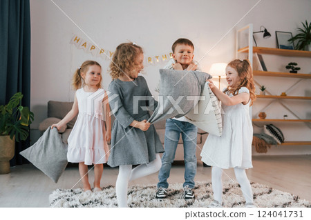 Pillow fight at birthday party. Group of children is together at home at daytime 124041731