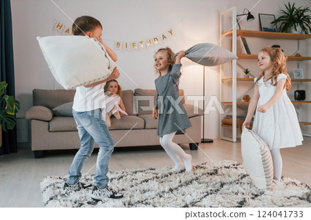 Pillow fight at birthday party. Group of children is together at home at daytime 124041733