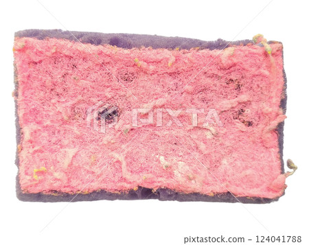 Closeup shot of a wellused cleaning sponge, exhibiting texture and wear.  The pink scrubbing surface shows signs of heavy use, conveying a sense of hard work and dedication. 124041788