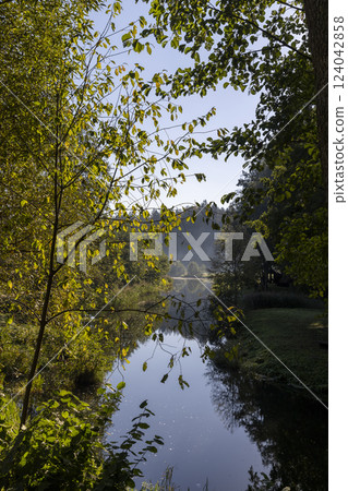 mixed forest and river in sunny weather in early August 124042858