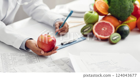 Doctor dietologist giving apple to afro woman patient during session, close up Doctor dietologist giving apple to afro woman patient during session, close up 124043677