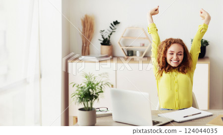 Break at work. Positive businesswoman relaxing at workplace, stretching her arms Break at work. Positive businesswoman relaxing at workplace, stretching her arms 124044035
