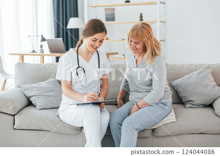 Nurse is giving prescription. Senior woman have consultation by young female doctor indoors 124044086