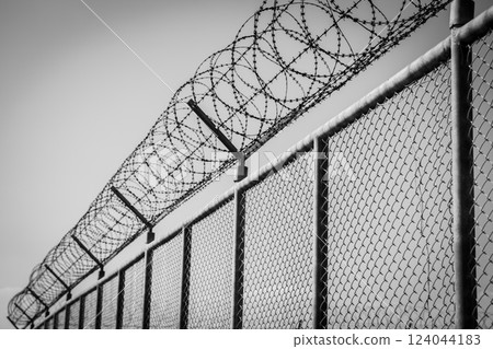 Prison security fence. Barbed wire border security fence. Razor wire jail fence. Barrier border. Boundary security wall. Prison for arrest criminals or terrorists. Private area. Military zone concept. 124044183