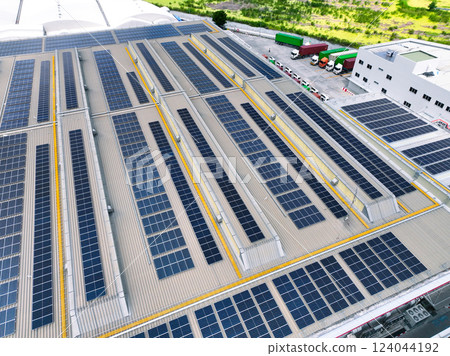 Solar-powered warehouse facility with freight trucks at loading docks. Eco-friendly logistics and efficient cargo transportation. Solar panels and sustainable energy concept in distribution center. Solar-powered warehouse facility with freight trucks at loading docks. Eco-friendly logistics and efficient cargo transportation. Solar panels and sustainable energy concept in distribution center. 124044192