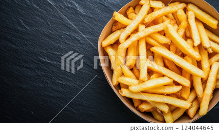 Crispy french fries in a brown paper bowl on a dark slate surface, AI Generative Crispy french fries in a brown paper bowl on a dark slate surface, AI Generative 124044645