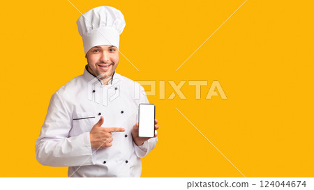 Smiling Chef Man Showing Smartphone Empty Screen Recommending Food Delivery Mobile App Standing Over Yellow Studio Background. Mockup, Panorama 124044674