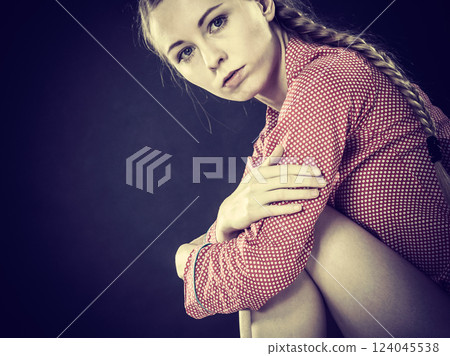 Sad depressed girl sitting huddled 124045538