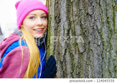 Woman wearing sportswear hugging tree 124045559