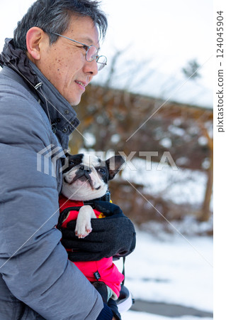 一名男子和他的狗在雪地裡玩耍 一名男子和他的狗在雪地裡玩耍 124045904