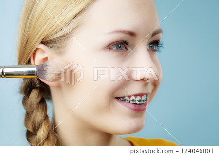 Makeup artist applying with brush rouge on female check Makeup artist applying with brush rouge on female check 124046001