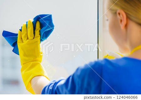 Woman using cloth to clean window glass Woman using cloth to clean window glass 124046066