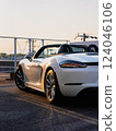 Porsche 718 Boxster convertible, illuminated orange by the setting sun 124046106