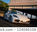 Porsche 718 Boxster convertible, illuminated orange by the setting sun 124046108