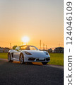 Sunset sky and Porsche 718 Boxster open car convertible 124046109