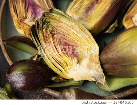 Plate full of cut purple raw artichokes top view. Fresh italian vegetables from farmers market 124046163