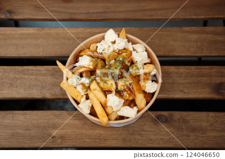 Poutine fries with chees and sauce in paper takeout container. Delicious freshly prepared meal, perfect for menus, restaurants, or food delivery concepts. Poutine fries with chees and sauce in paper takeout container. Delicious freshly prepared meal, perfect for menus, restaurants, or food delivery concepts. 124046650