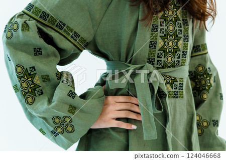 Close-Up View of Woman's Green Linen Dress With Intricate Traditional Embroidery Close-Up View of Woman's Green Linen Dress With Intricate Traditional Embroidery 124046668