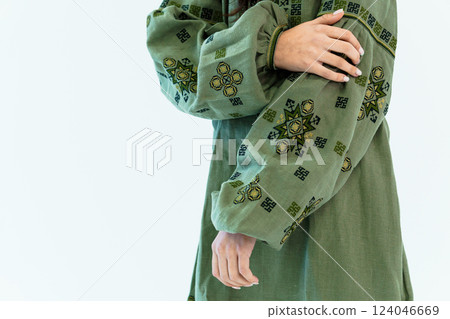 Close-up of woman wearing traditional green embroidered ethnic dress with intricate geometric patterns 124046669