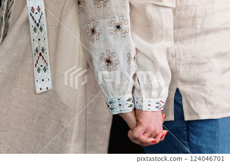Close-Up of Couple Holding Hands Wearing Traditional Embroidered Shirts 124046701