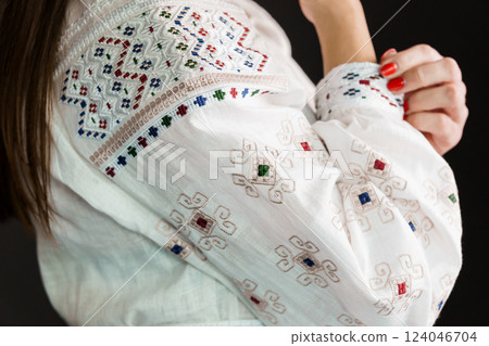 Close-up of Traditional Embroidered White Fabric with Ethnic Decorative Patterns and Female Hand Close-up of Traditional Embroidered White Fabric with Ethnic Decorative Patterns and Female Hand 124046704