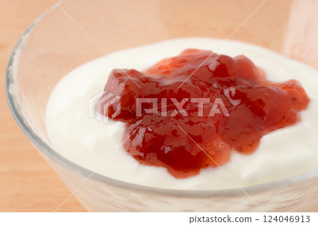 Close-up of strawberry jam poured over yogurt 124046913