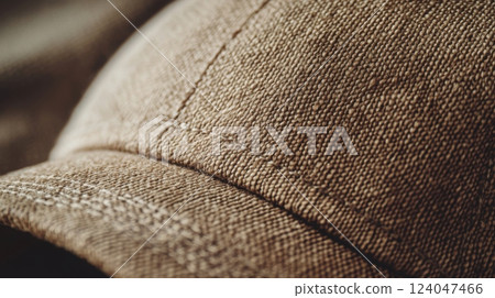 A detailed view of a brown cap highlighting its textured fabric and stitching, illuminated by soft natural light. 124047466