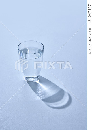 View from above of clear glass with transparent liquid against white studio background. One glass of water. Mock up. 124047567