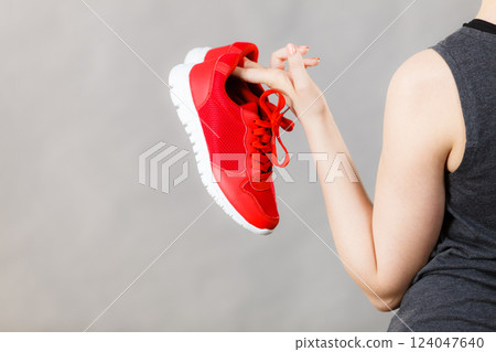 Woman presenting sportswear trainers shoes Woman presenting sportswear trainers shoes 124047640