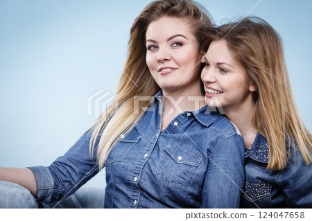 Two happy women friends wearing jeans outfit 124047658