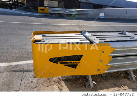 Crash cushion barrier at end of road barricade for safety. They absorb impact in the event of automobile crash 124047758