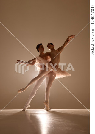 Dancers create sweeping lines in perfect synchrony, warm stage light outlining expressive gestures. Concept of ballet rhythm, art. Dancers create sweeping lines in perfect synchrony, warm stage light outlining expressive gestures. Concept of ballet rhythm, art. 124047815