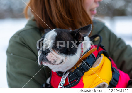 A woman and her dog playing in the snow 124048123