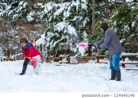 Couple playing in the snow 124048140