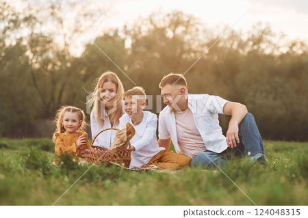 Sitting on the green grass. Family have weekend outdoors at summertime together 124048315