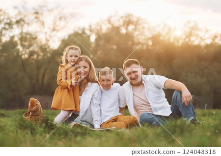 Sitting on the green grass. Family have weekend outdoors at summertime together 124048318