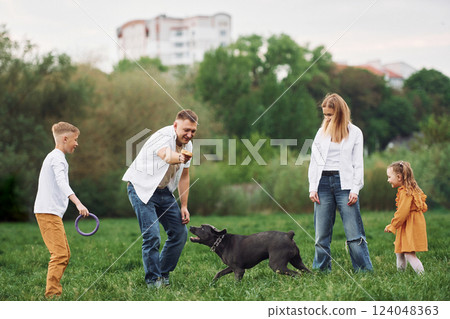 Walk with dog. Family have weekend outdoors at summertime together Walk with dog. Family have weekend outdoors at summertime together 124048363
