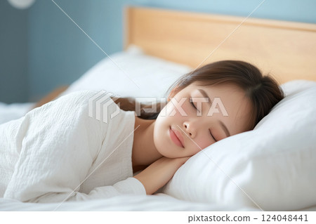 Cozy tranquil bedroom scene with a woman sleeping peacefully 124048441