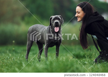 Young brunette is having a walk with her dog outdoors 124048468